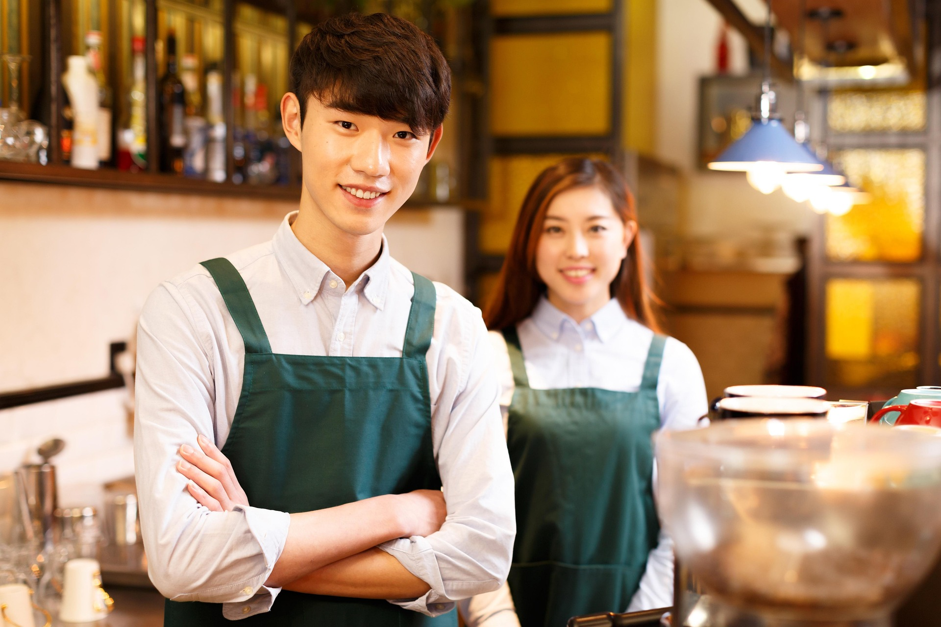 Young service staff working behind a cafe counter.